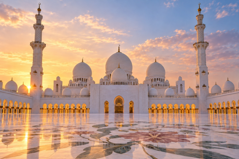 Sheikh Zayed Grand Mosque in Abu Dhabi at sunset with white marble domes and reflective pools